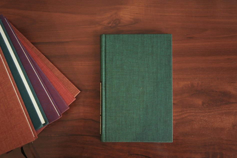 Buch auf Holzschreibtisch mit der Präambel von erlebnisreich wohnen